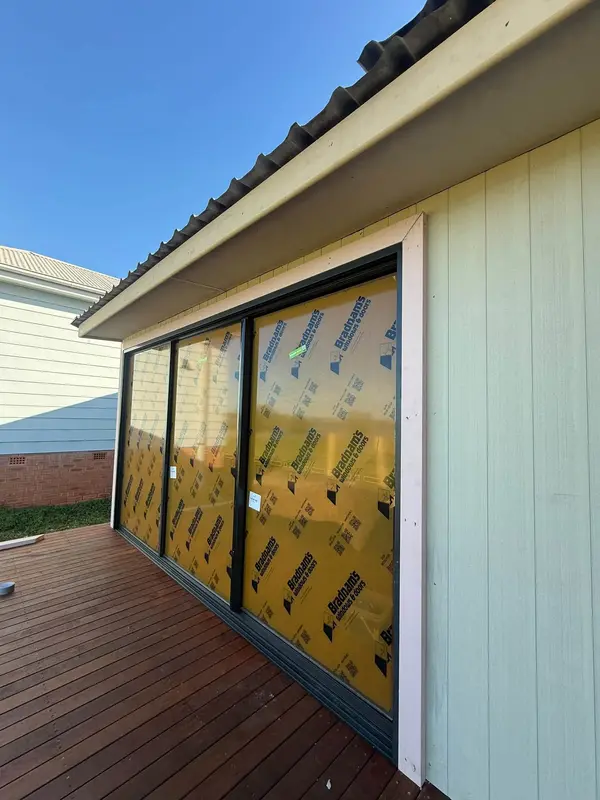 House extension with weatherboard cladding, wide sliding doors and a new timber deck