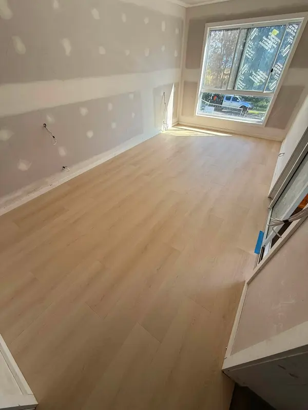 Interior fit-out with new timber-look flooring in a bright room with a large window